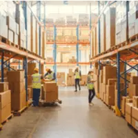 Employees inside a warehouse taking inventory of boxes