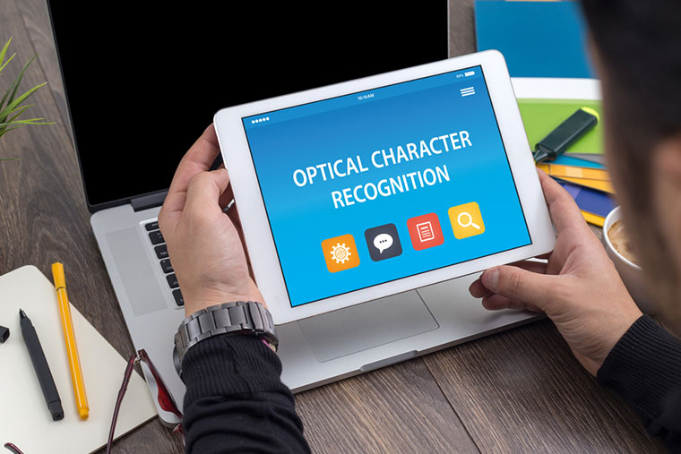 Man holding tablet that says Optical Character Recognition. One of the main services for Legal firms